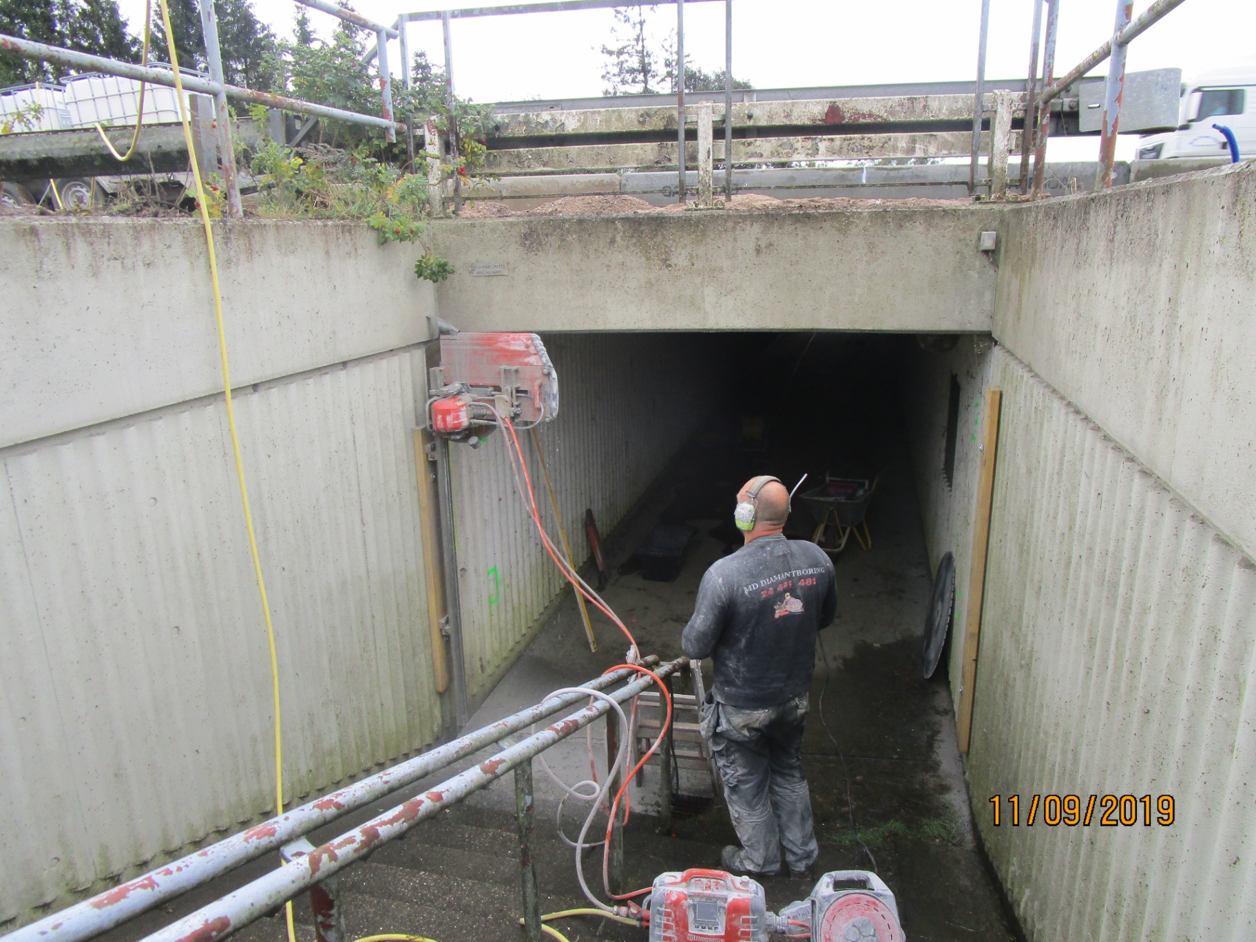 Håndværker udfører diamantskæring i tunnel